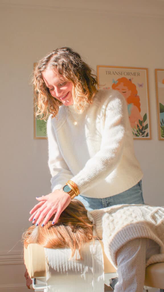 Photo de Lucile Bartringer Chiropracteur à Annecy en train de poser ses mains sur la tête d'une patiente pour l'ajuster au centre de chiropraxie d'Annecy