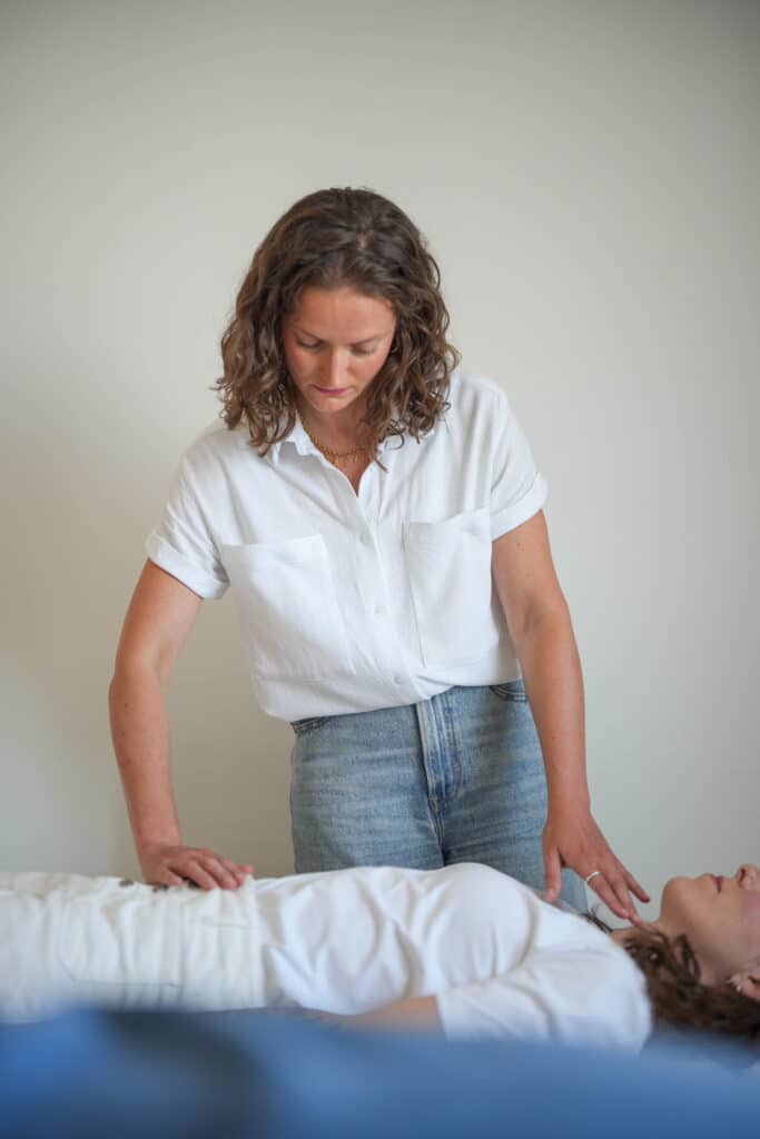Photo de Lucile Bartringer, chiropracteur à Annecy en train de poser ses mains pour effectuer un soin chiropratique sur une femme anxieuse