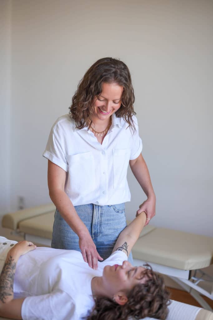 Photo de Lucile Bartringer Chiropracteur à Annecy en train de poser ses mains sur la tête d'une patiente pour l'ajuster au centre de chiropraxie d'Annecy